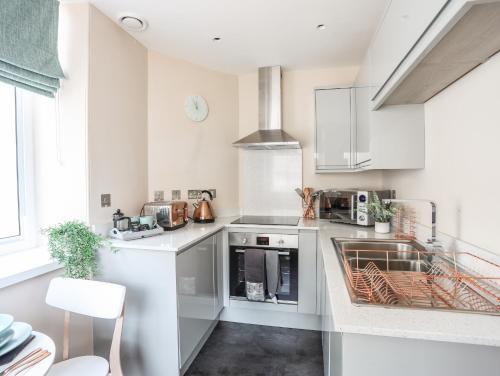 a kitchen with white cabinets and a stove top oven at Nantlle in Caernarfon