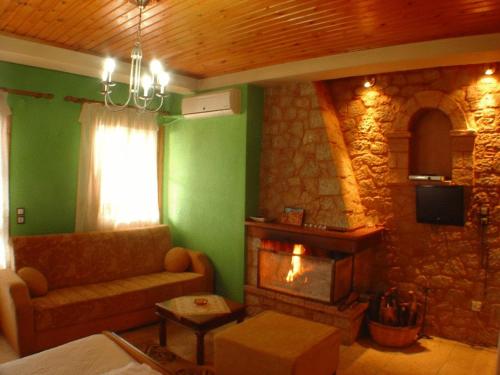 a living room with a couch and a stone fireplace at Ariadne Guesthouse in Arachova