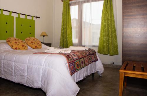 una camera da letto con un letto con tende verdi e una finestra di Cielos Patagónicos Aparts a El Calafate