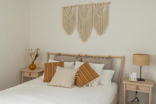 a bedroom with a bed with pillows and a m sign on the wall at LXR Waikiki Beach Front 3Hab. Tarifa in Tarifa