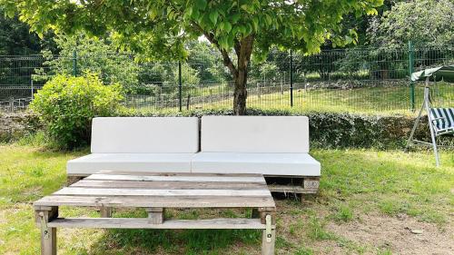 a white couch sitting on a wooden bench in the grass at Hotel Avelina in Cangas de Onís