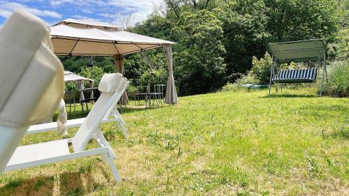 two lawn chairs and an umbrella in a yard at Hotel Avelina in Cangas de Onís