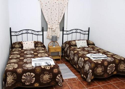 two beds sitting next to each other in a bedroom at Casa Rural Hinojosa Del Duque in Hinojosa del Duque