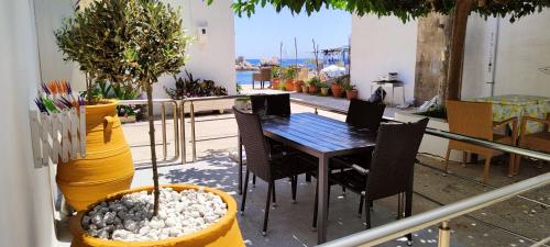 a table and chairs on a balcony with plants at Haraki Endless Blue Luxury Apartments in Haraki