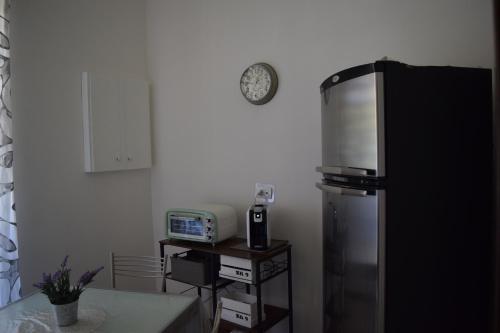 una cucina con frigorifero e orologio a parete di Residenza Lo Bello Vedere a Caserta