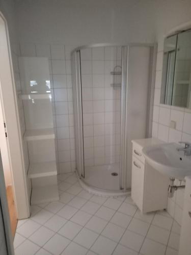baño blanco con ducha y lavamanos en Ferienwohnung Murtal, en Sankt Lorenzen bei Knittelfeld