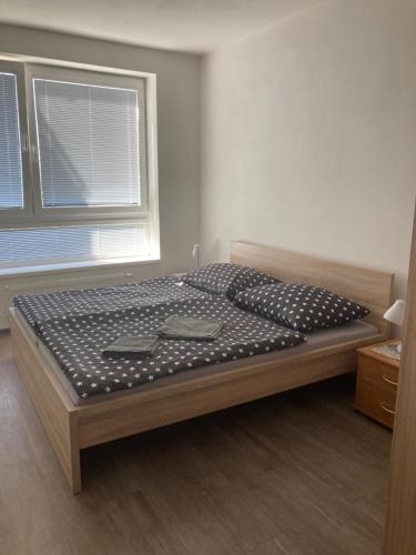 duże łóżko w pokoju z oknem w obiekcie Apartmán EDITA - byt s terasou a parkovacím stáním, Topolová, Olomouc w Ołomuńcu