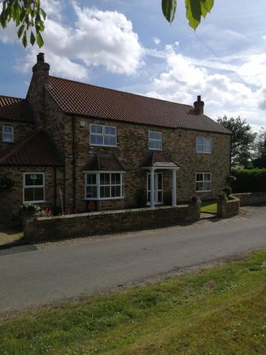 a brick house on the side of a road at The Old School in Donington on Bain