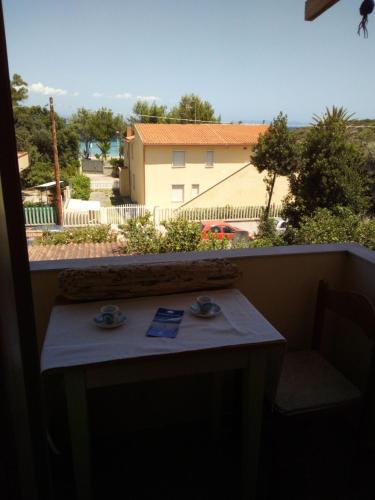 Maladroscia的住宿－La spiaggetta Maladroxia BIANCA，阳台的桌子,享有建筑的景色