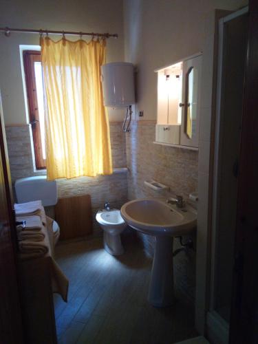 bagno con lavandino, servizi igienici e finestra di La spiaggetta Maladroxia BIANCA a Maladroscia