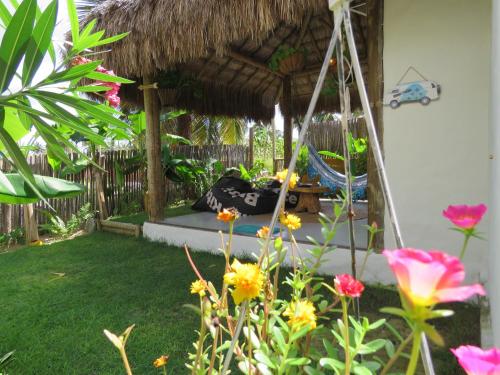 a garden with a swing and some flowers at Chill Kite - Pousada Icaraí Kite Village in Icaraí