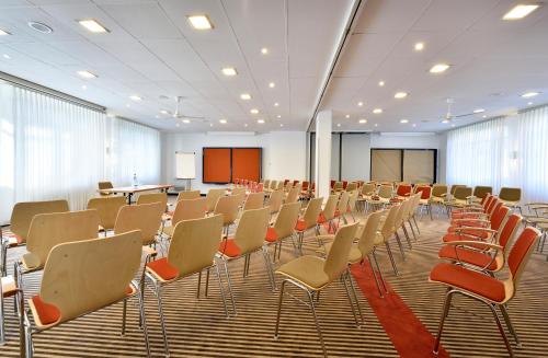 an empty room with chairs and a podium in a room at das seidl - Hotel & Tagung - München West in Puchheim
