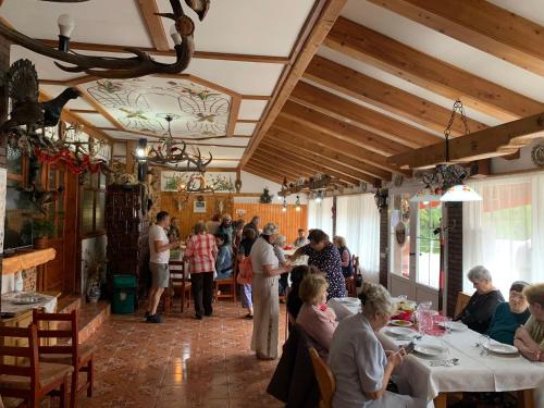 a group of people sitting at tables in a restaurant at Cabana Cerbul-Oasa-Transalpina in Ciban