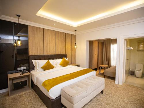a bedroom with a large bed and a bathroom at Prosbel Hotel in Abuja