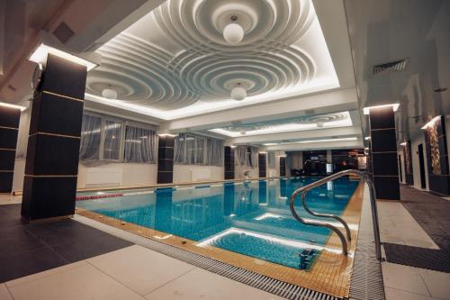 a large swimming pool in a building with a ceiling at Stella Residence Club in Odesa