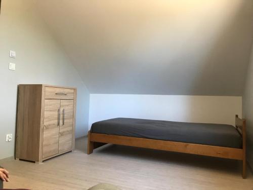 Schlafzimmer mit einem Bett und einem Holzschrank in der Unterkunft Leśny Domek 