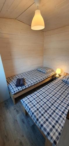 Habitación con 2 camas en una habitación de madera en Dębina Domki Jałowcowa 8, en Debina
