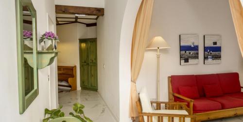 a living room with a red couch and a green door at Villa Xemxija in Xlendi
