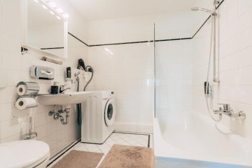 a bathroom with a toilet sink and a shower at Luga Homes - Nikolaikirche in Leipzig