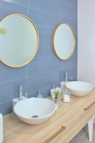 a bathroom with two sinks and two mirrors at Apartamento Circo Romano- con vistas al Circo Petfriendly in Mérida