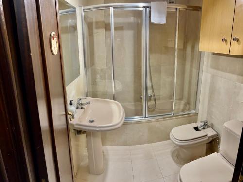 a bathroom with a shower and a sink and a toilet at APARTAMENTO SAPPORO VIELHA in Vielha