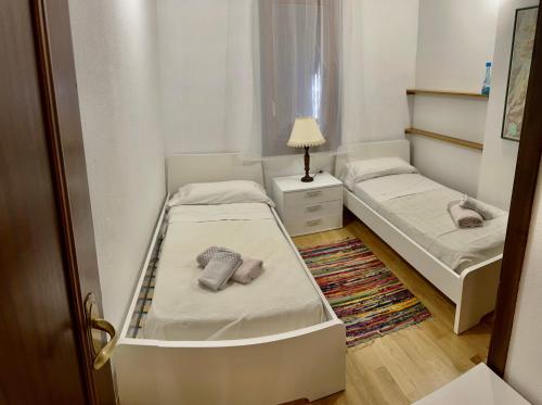 a small room with two beds and a lamp at APARTAMENTO SAPPORO VIELHA in Vielha