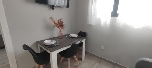 a dining room table with two chairs and a vase on it at Apartamentos Las trece llaves Jacuzzi bajo reserva in Merida