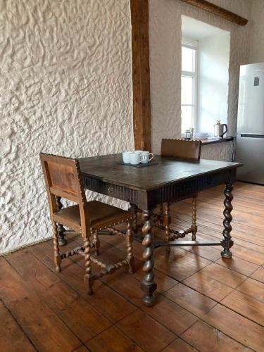 een houten tafel met een stoel en een koelkast bij Saue 10 in Haapsalu
