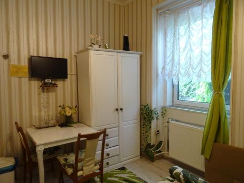 a room with a desk and a tv and a window at Guesthouse Ilona in Veľký Kamenec