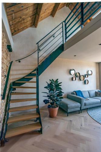 a living room with a spiral staircase and a couch at Luxe appartementen Havenzicht in Sint Annaland