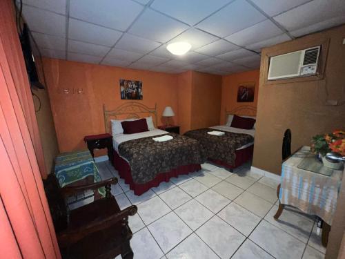 a hotel room with two beds and a table at Hotel Maya Copan Guamilito in San Pedro Sula