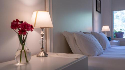 a vase of red flowers on a table next to a couch at Suites Camacho in Carmelo