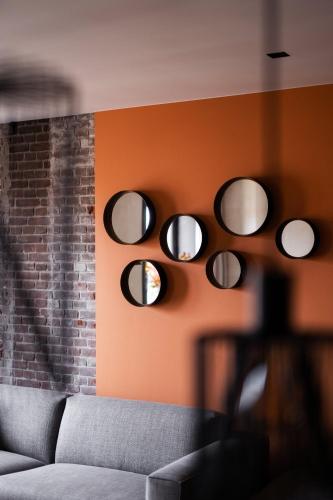 a room with a couch and circular mirrors on the wall at Luxe appartementen Havenzicht in Sint Annaland