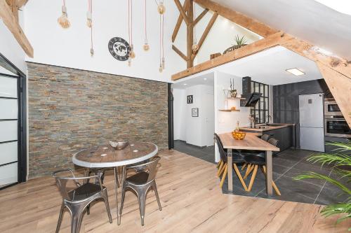 une cuisine et une salle à manger avec un mur en briques dans l'établissement l'authentique en hyper centre ville, à Beauvais