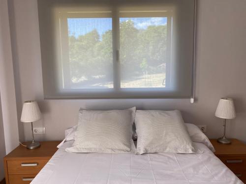 La Portella في Pauls de Flamisells: سرير مع وسادتين ونافذة فوقه