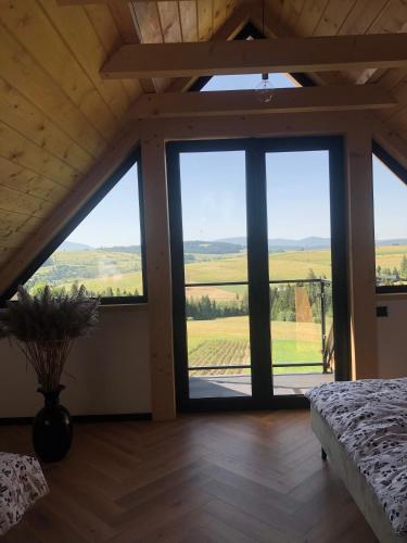 a bedroom with a large window with a view at Czarne Jodły in Jabłonka