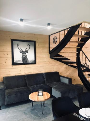 a living room with a black couch and a table at Czarne Jodły in Jabłonka