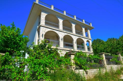 un gran edificio en la parte superior de una pared de piedra en Apartments Rajsko Mjesto en Tivat