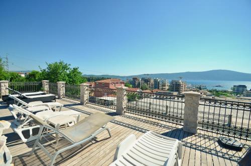 una terraza con tumbonas y vistas al agua en Apartments Rajsko Mjesto en Tivat