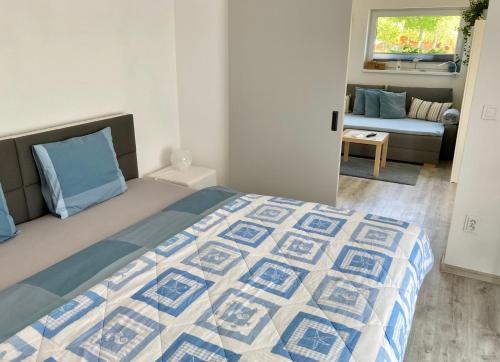 a bedroom with a bed with a blue and white quilt at Apartmán Nad Přehradou in Frýdek-Místek