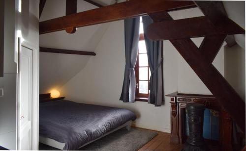 a small bedroom with a bed and a window at Top floor appartment Edam in Edam