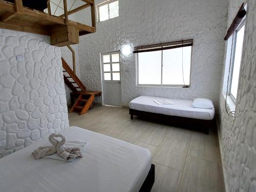 1 dormitorio con 2 camas y un osito de peluche en la cama en Hotel Cabaña Playa DanRay, en Coveñas