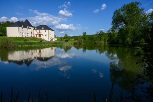 una casa grande en una colina junto a un lago en Domaine de Lardoisière en Château-Salins