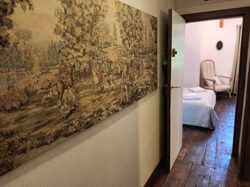 une tapisserie accrochée à un mur dans une pièce dans l'établissement Chambres d'hôtes Le Veilleur de Noblat, à Saint-Léonard-de-Noblat