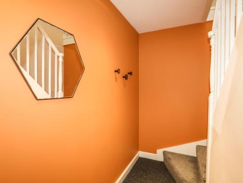a hallway with orange walls and a mirror at Moel Tryfan in Caernarfon