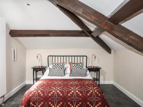 a bedroom with a red bed with two tables at Moel Tryfan in Caernarfon