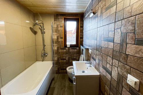 a bathroom with a tub and a toilet and a sink at Zagroda Nad Kotelnią in Pawłowa