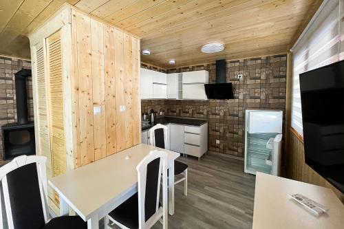 a kitchen and dining room with a table and chairs at Zagroda Nad Kotelnią in Pawłowa