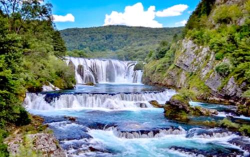 a waterfall in the middle of a river at Motel Medium in Bihać