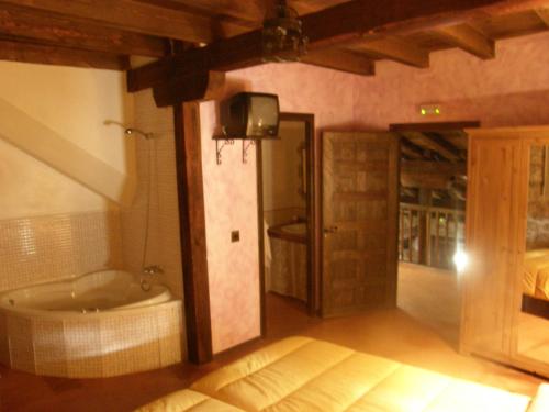 Habitación con baño con bañera y TV. en Posada del Dulce Sueño, en Mojares